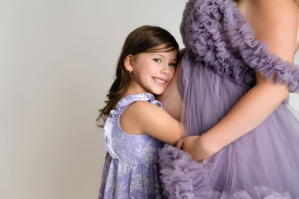 A child in a purple ruffled dress poses elegantly while dancing and twirling in different positions.