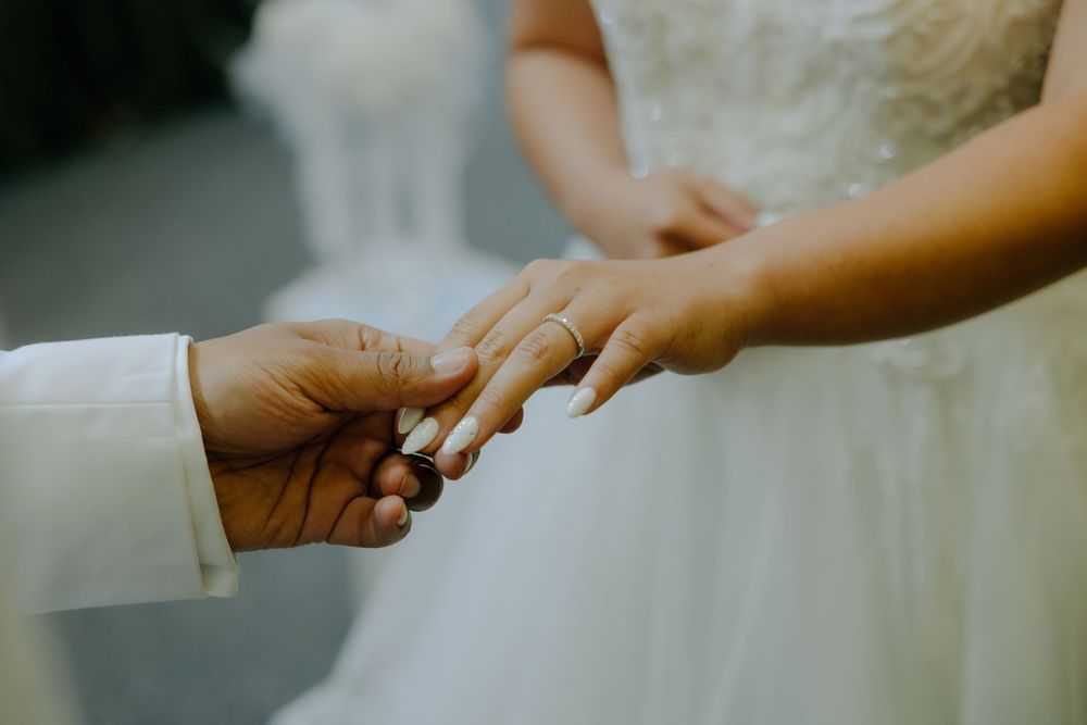 Hands holding white fabric delicately swap between each other in sequence against a blurry background.