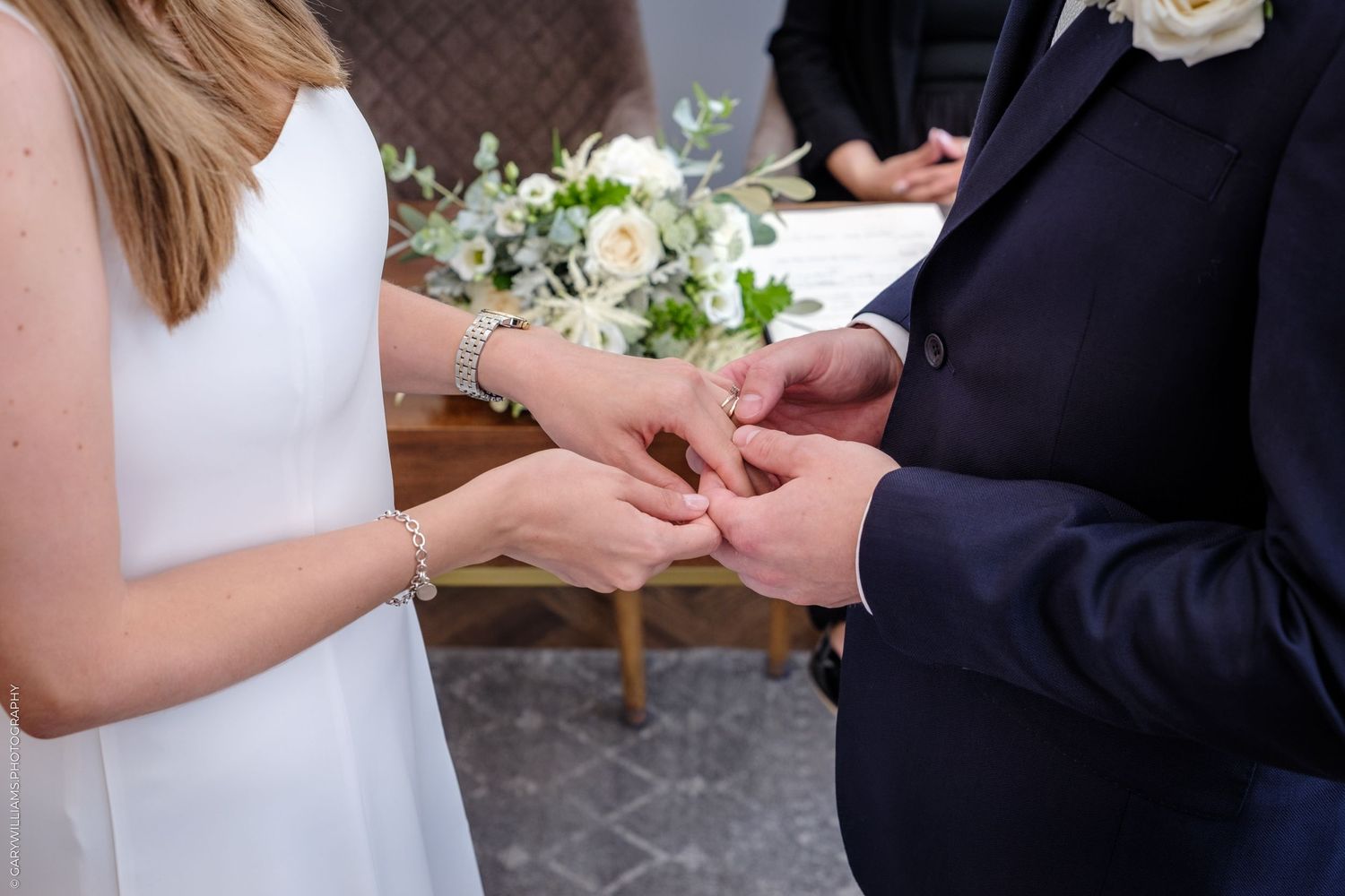 Close-up of hands exchanging wedding rings during a romantic ceremony.