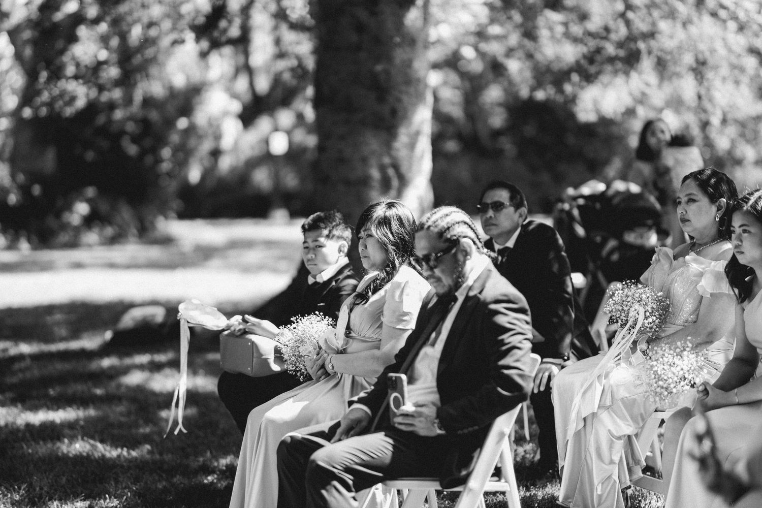 A black and white candid photo sequence shows celebration and laughter at an outdoor wedding reception gathering.