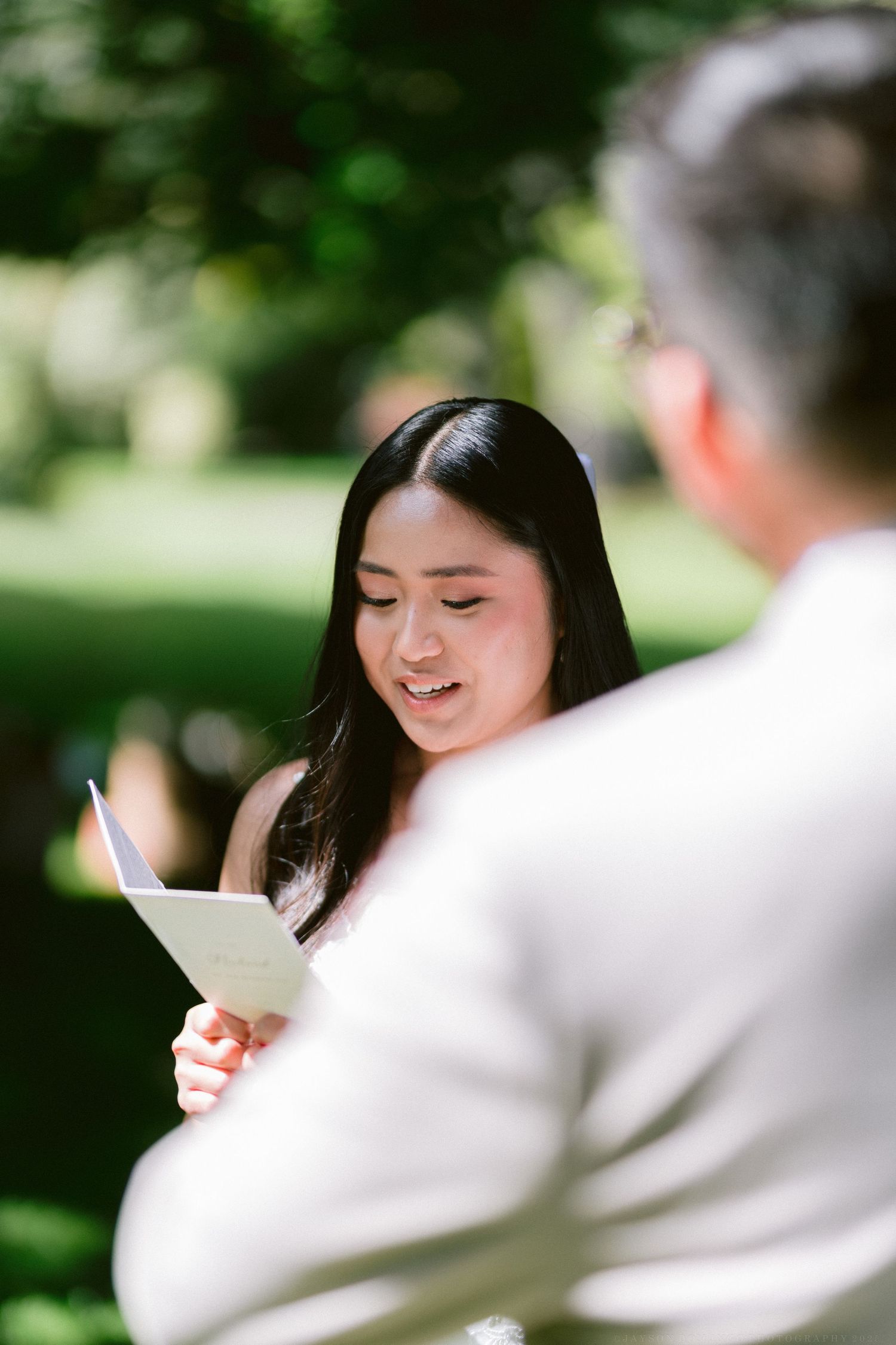 A collage of candid moments reading from a letter or paper in an outdoor garden setting.