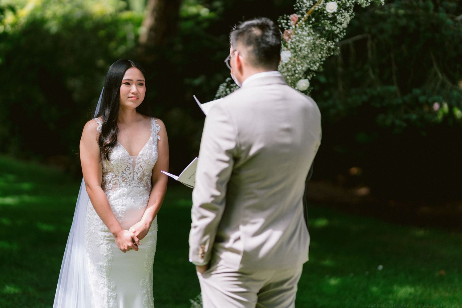 A bride and groom share an intimate moment during their outdoor garden wedding photography session.