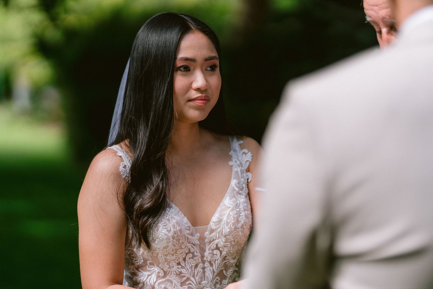 An intimate outdoor wedding moment with soft natural lighting and lush greenery.