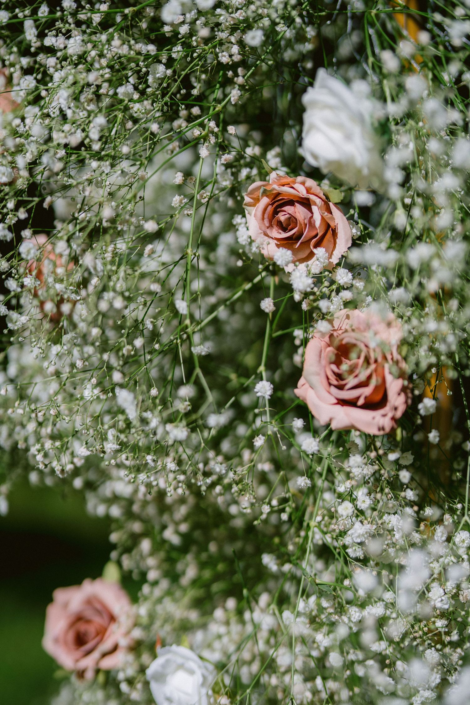 Delicate pink roses nestled among white baby's breath flowers create a romantic floral arrangement.