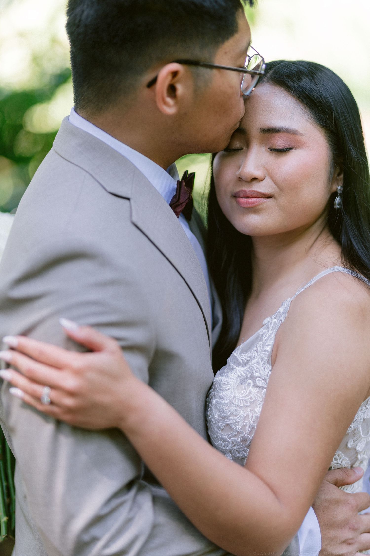 A romantic moment between newlyweds sharing an intimate embrace outdoors.