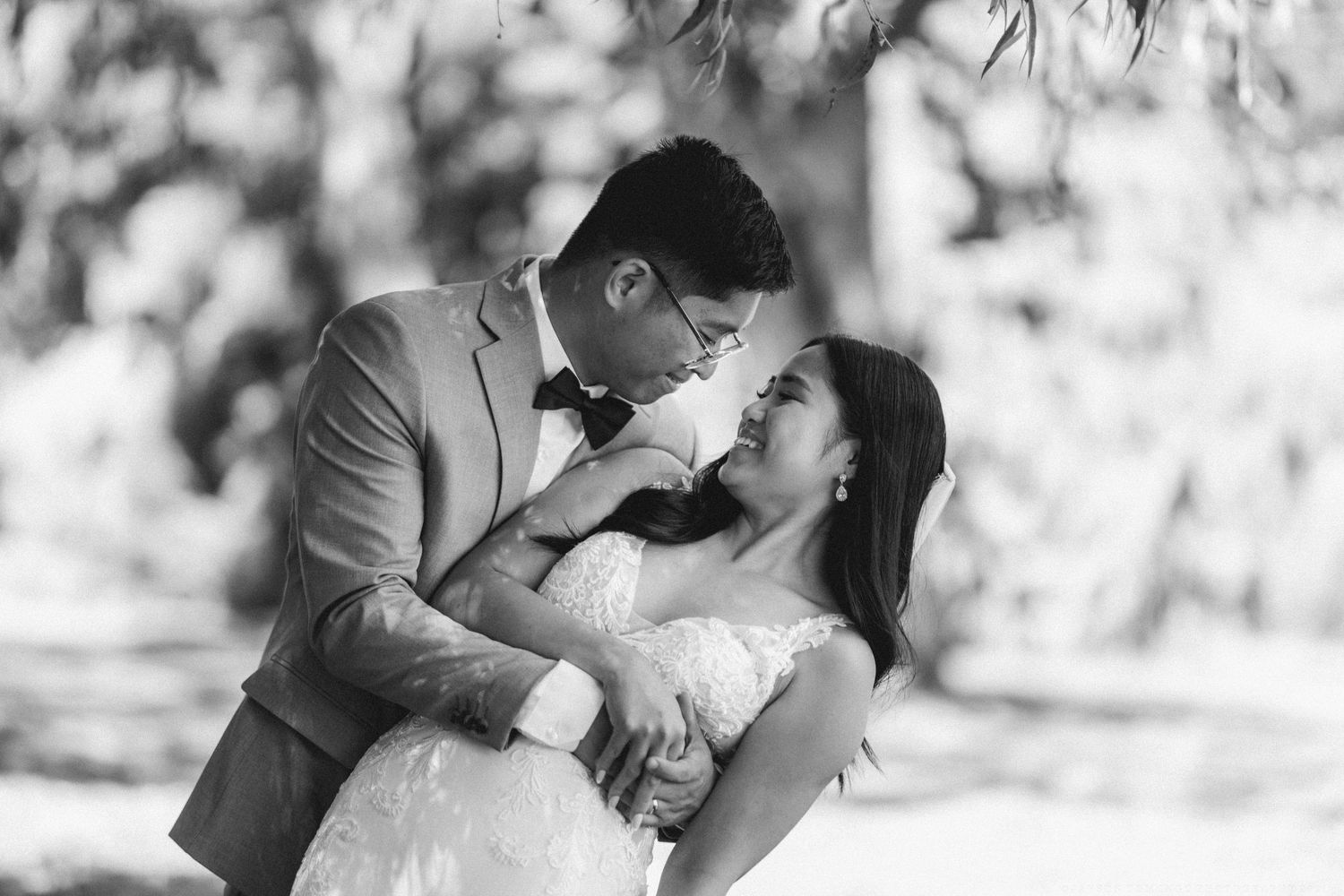 A romantic black and white portrait of a couple sharing an intimate moment on their wedding day.