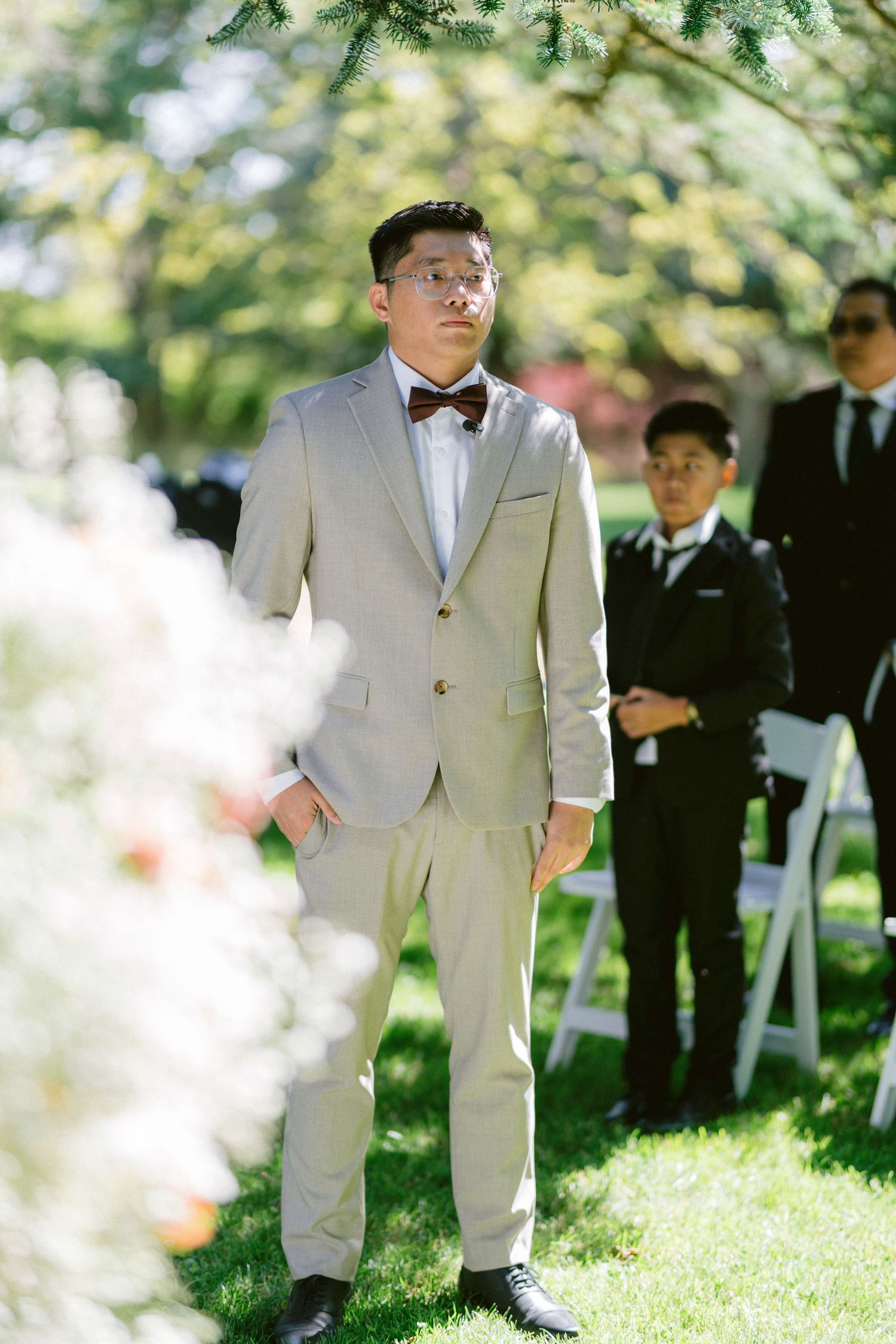 A wedding ceremony setup outdoors with elegant decor and attendees in formal attire.