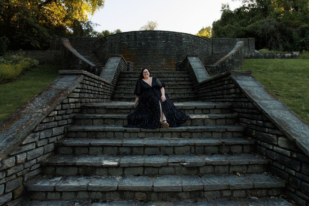 Dramatic portrait on stone steps in black dress during golden hour. Outdoor portrait photography at Fort Belle Fontaine in Missouri