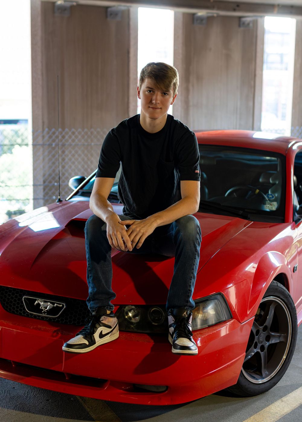 A red sports car photographed near the St. Louis Gateway Arch on a sunny day. Portrait photography. Senior Photography