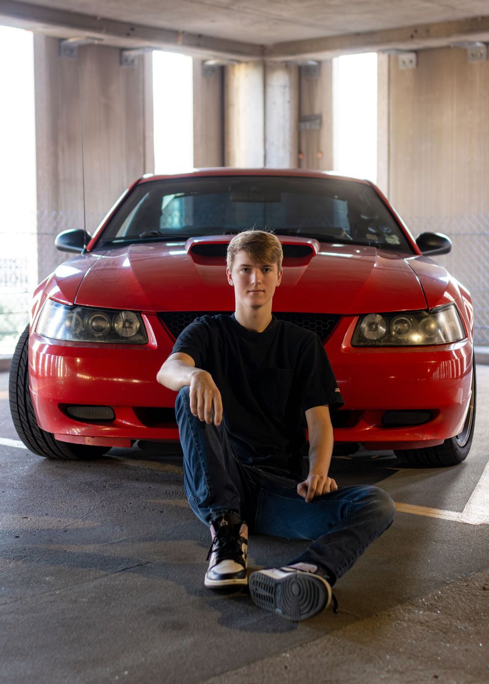 A red sports car photographed near the St. Louis Gateway Arch on a sunny day. Portrait photography. Senior Photography