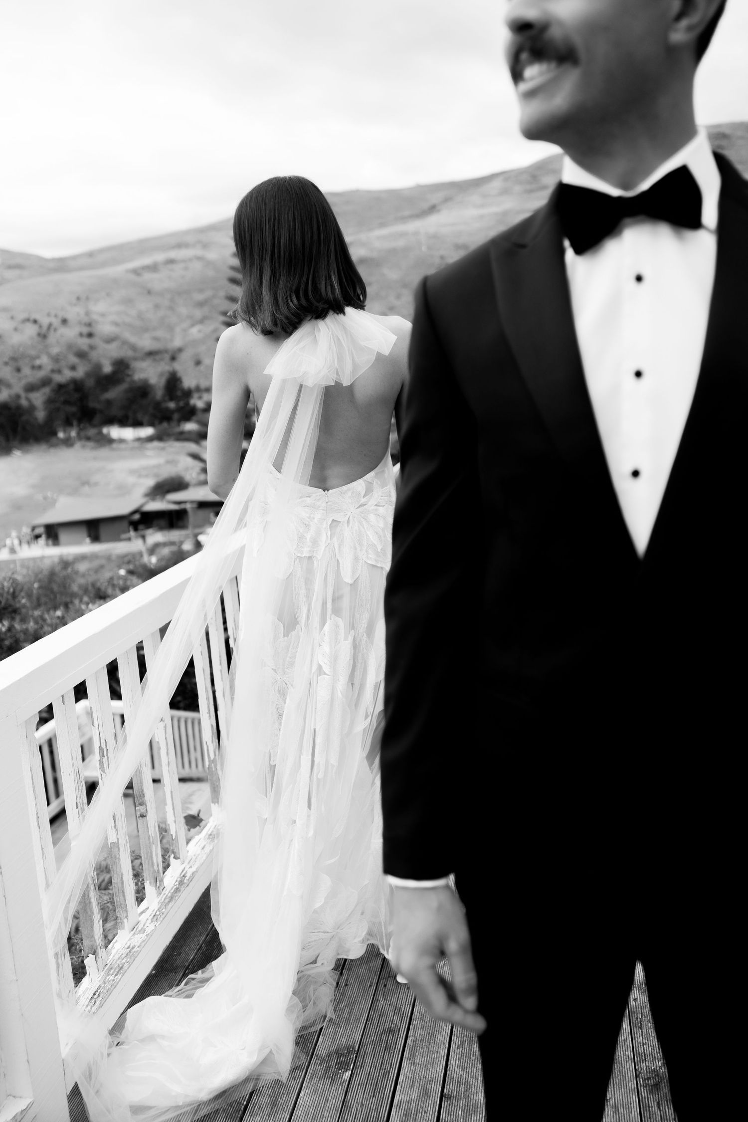 Black and white series showing couple in formal wear on white balcony.