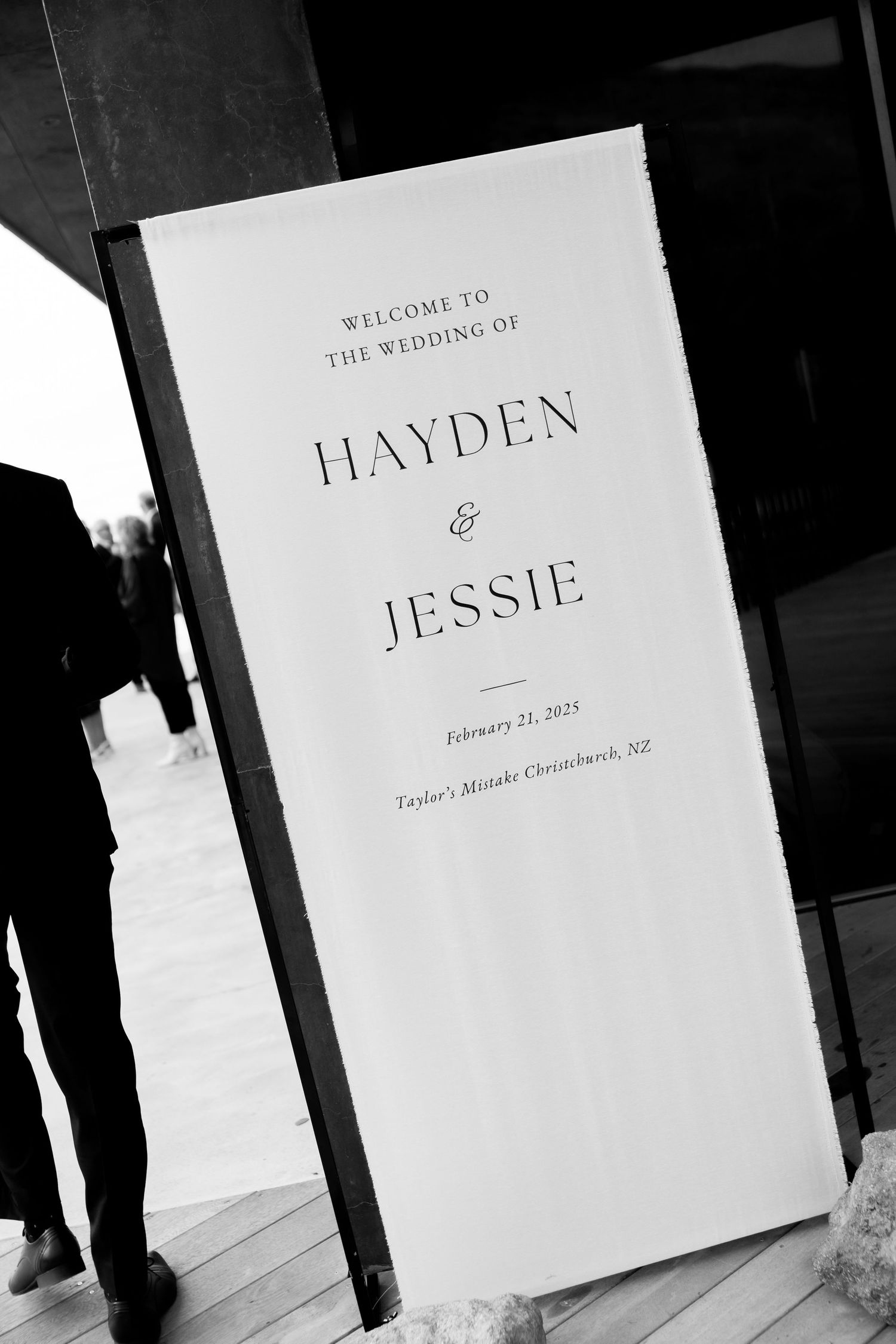 Wedding welcome sign displays names Hayden and Jessie in elegant typography.