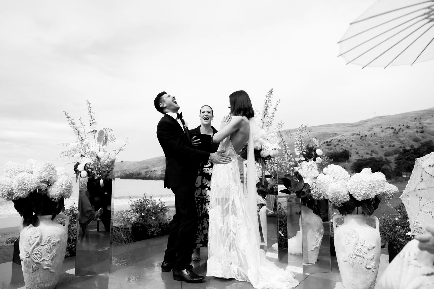 Wedding ceremony moment captured against mountain backdrop with floral arrangements.