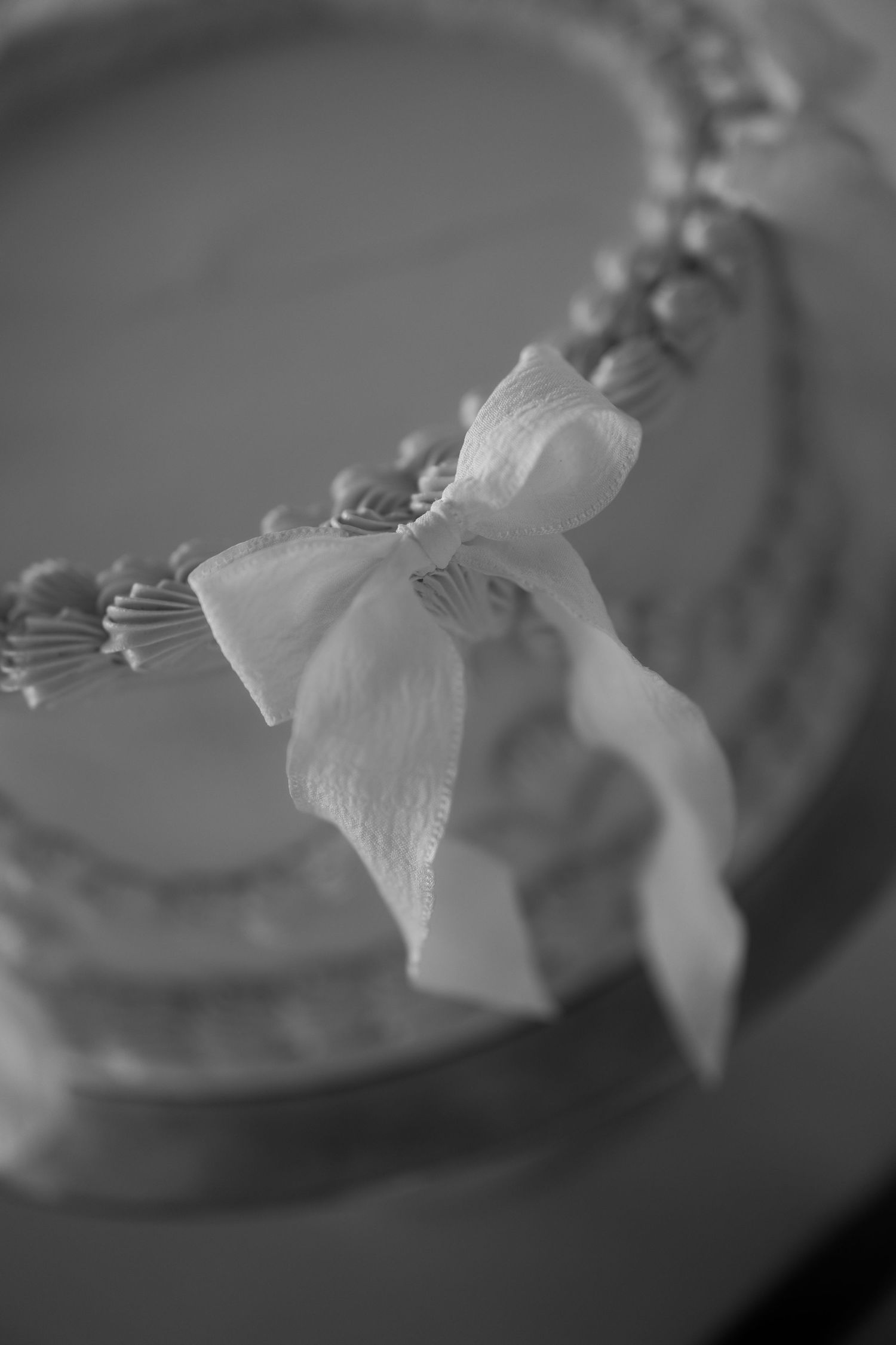 A delicate white bow tied around beaded jewelry in black and white.