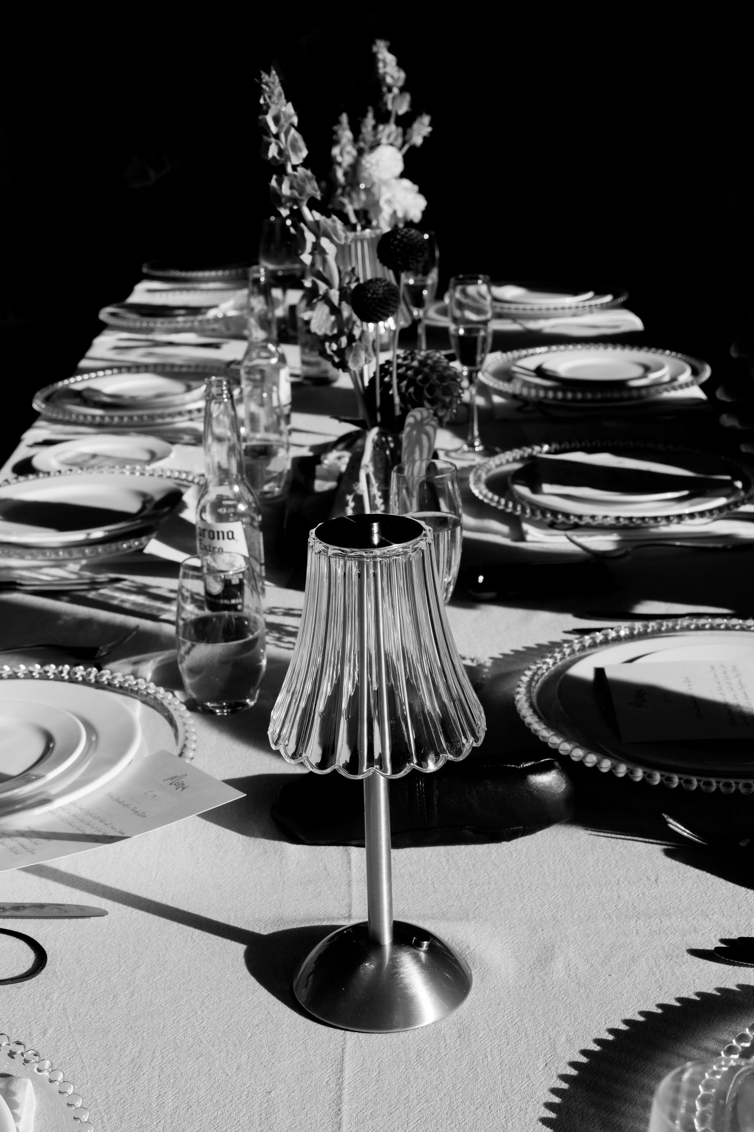 An elegant table setting with place settings and floral centerpiece in black and white.