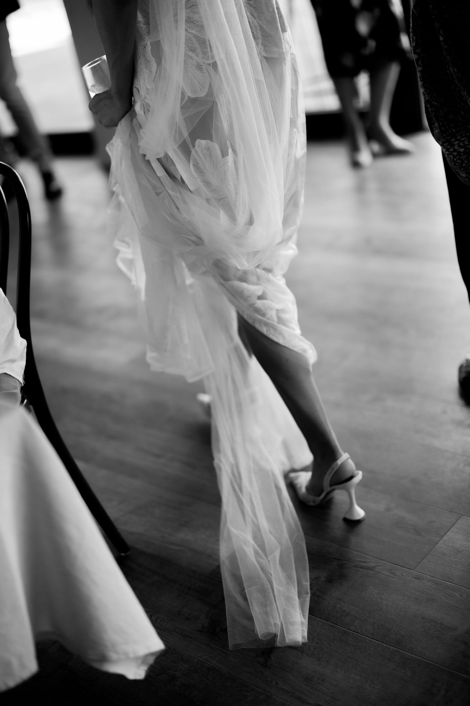 Close-up shots of a flowing white wedding dress and shoes during a dance.