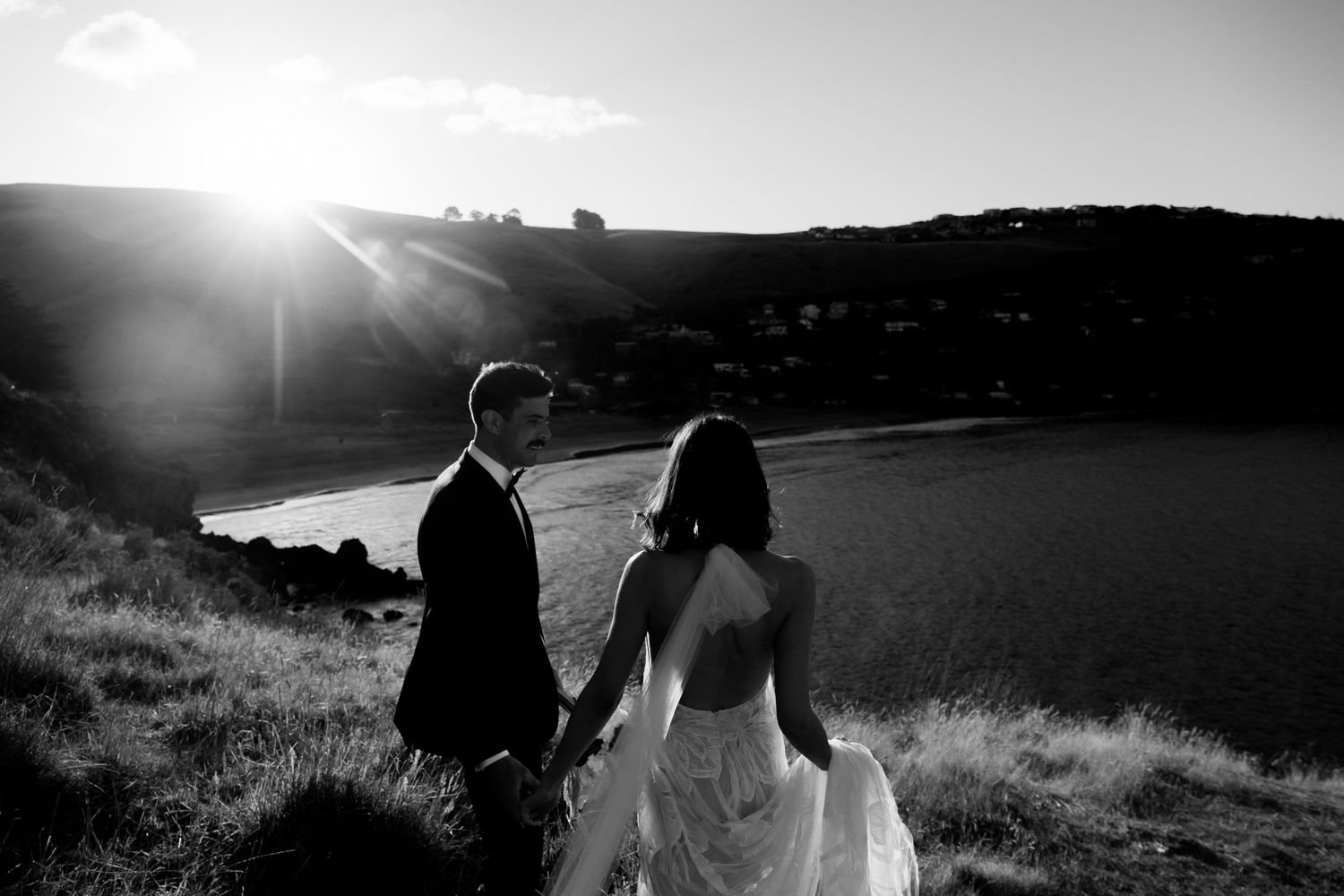 Silhouetted couple poses against dramatic sunset for romantic wedding photos.