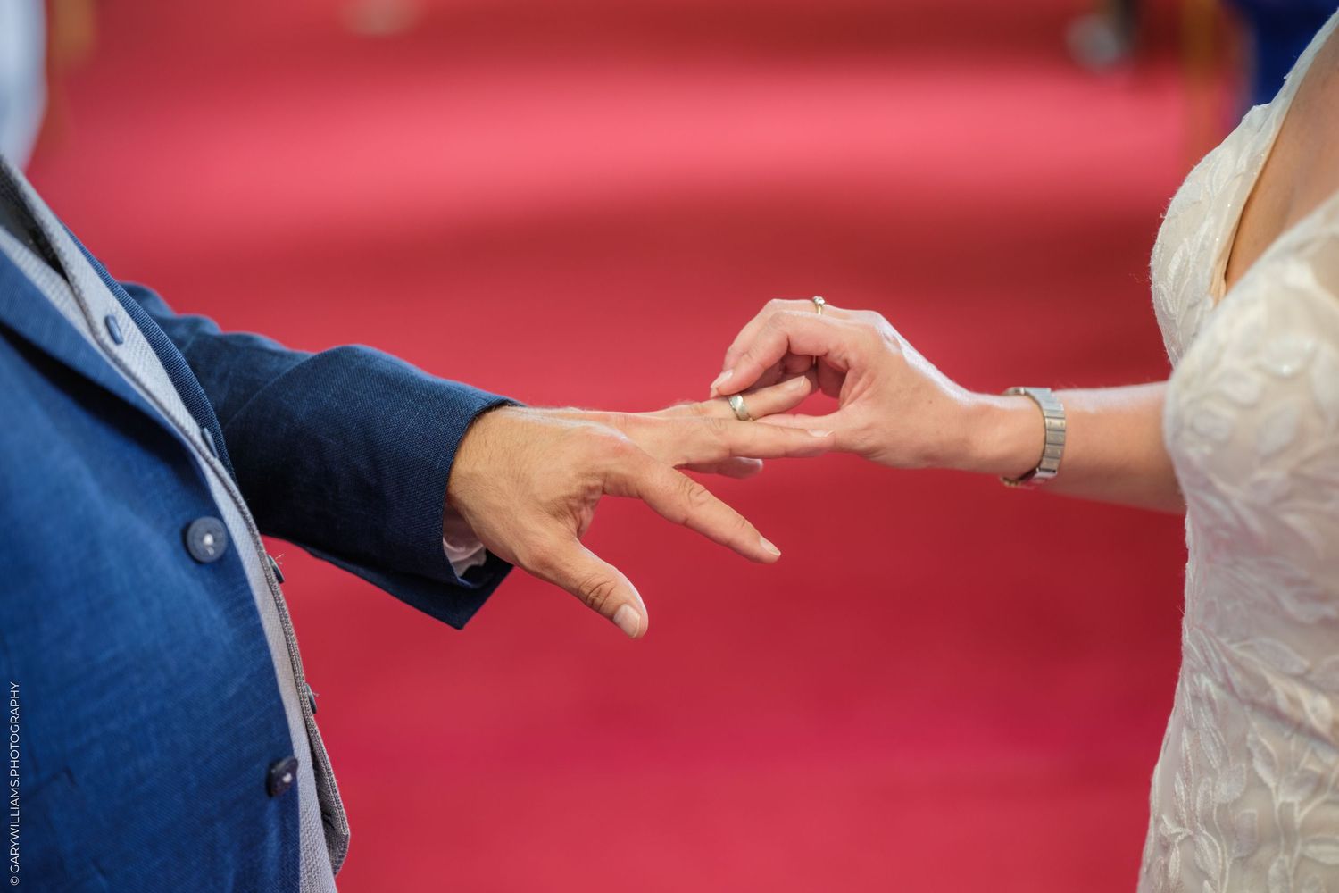 People's hands come together to form a circle, symbolizing unity and connection on a red background.