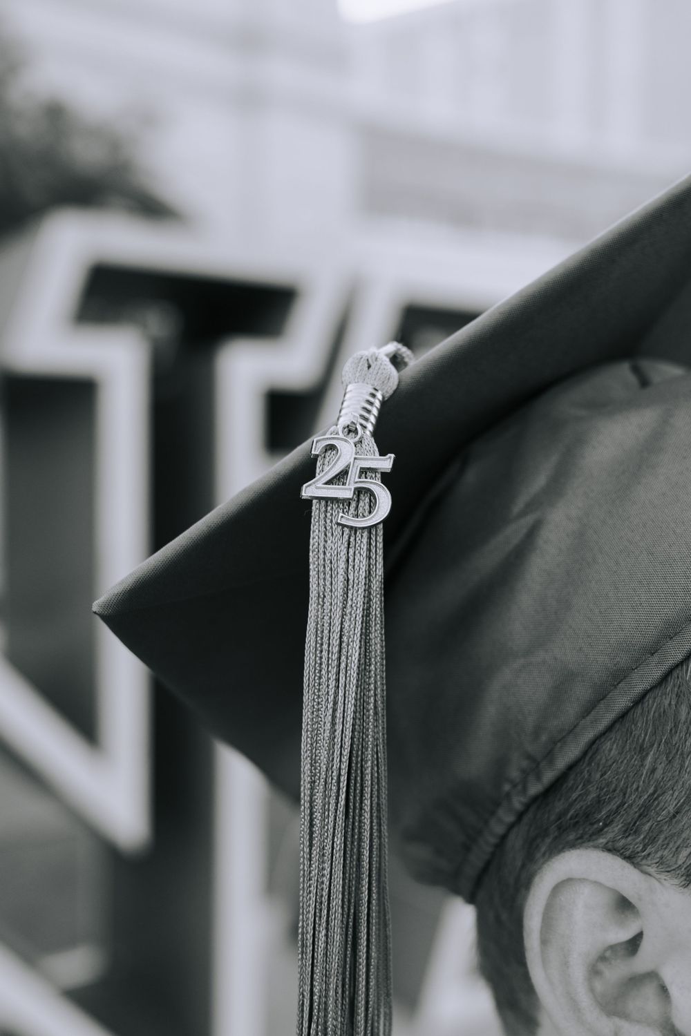 Close-up of graduation cap tassels in black and white.