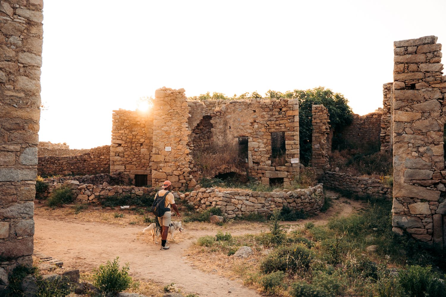 promeneur et son chien au milieu des ruines de village d'occi au coucher du soleil
