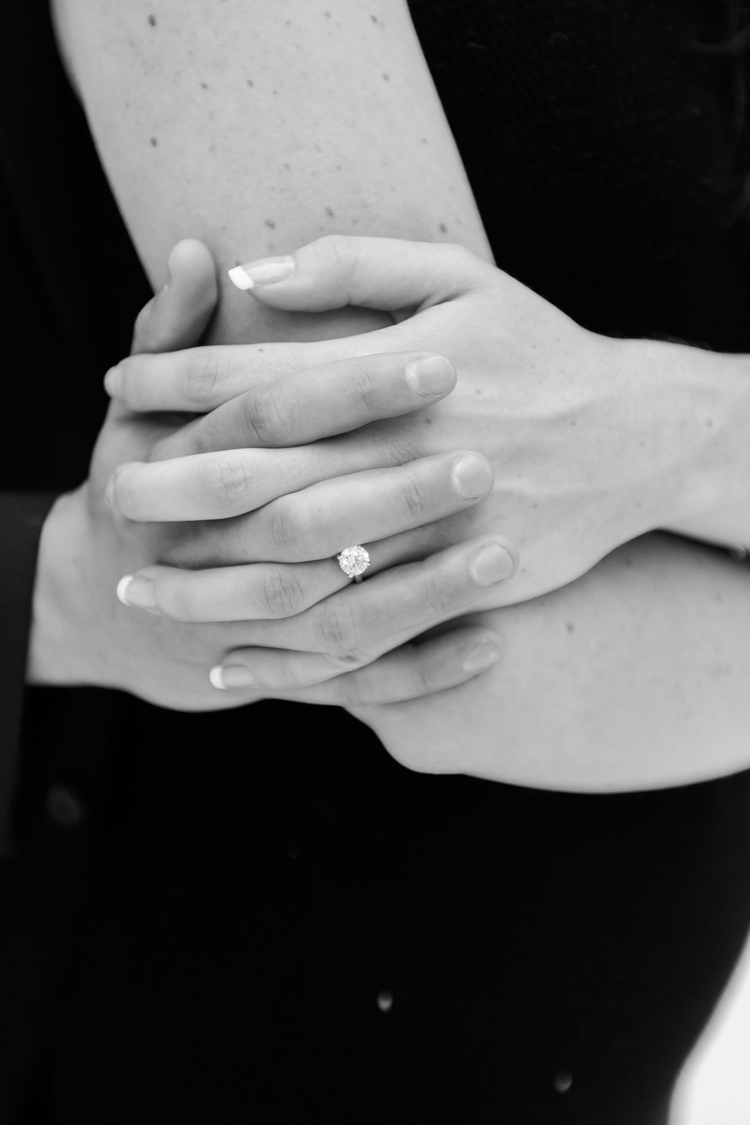 Black and white sequence showing hands exchanging an engagement ring.