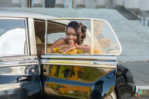 Closeup views of a vintage black car with chrome details parked at a formal event.