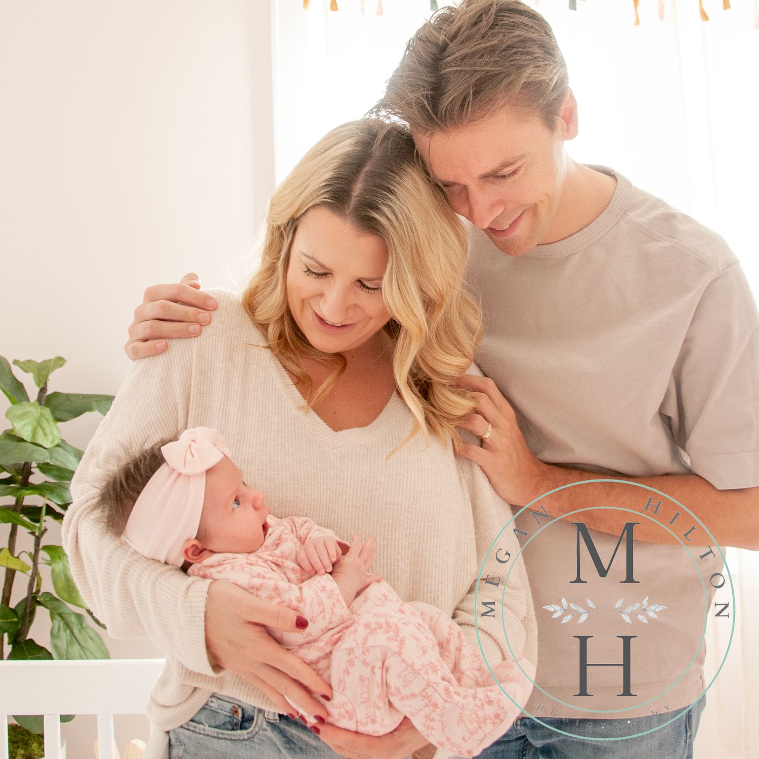 Mom and dad holding a newborn baby girl in a nursery