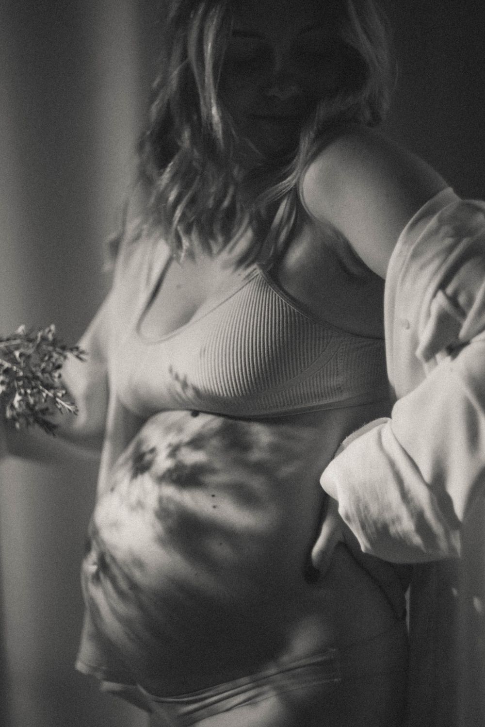 Dramatic black and white maternity boudoir photos with soft lighting.
