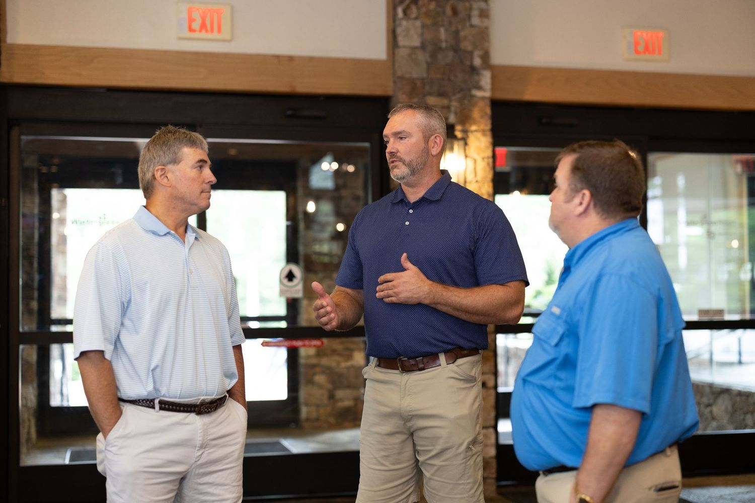 Business casual networking event in office setting with people engaged in conversation.