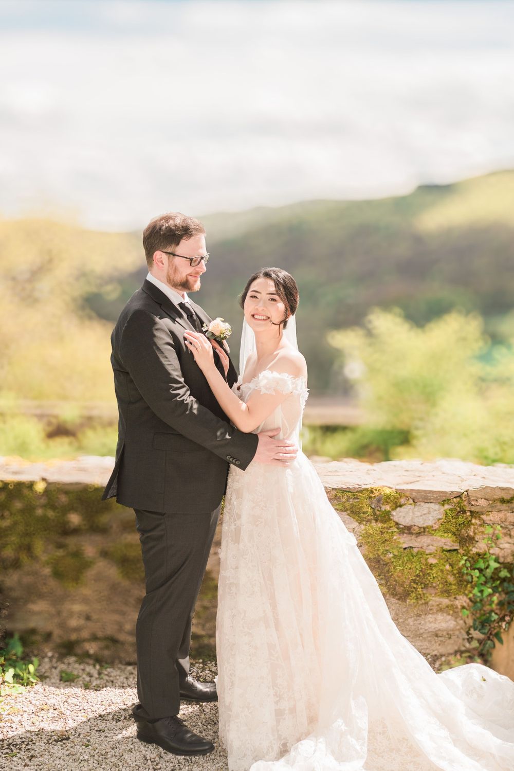 Wedding couple embraces while posing for romantic portrait in mountain setting.