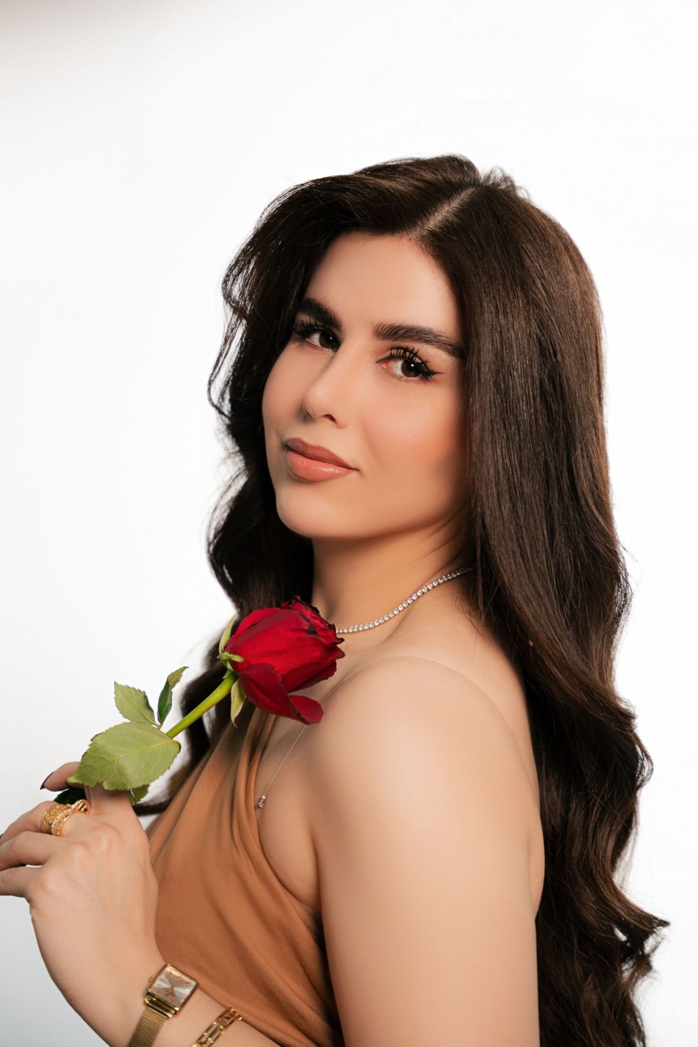 Three glamour portraits show a woman in a brown top posing with a red rose against a light background.