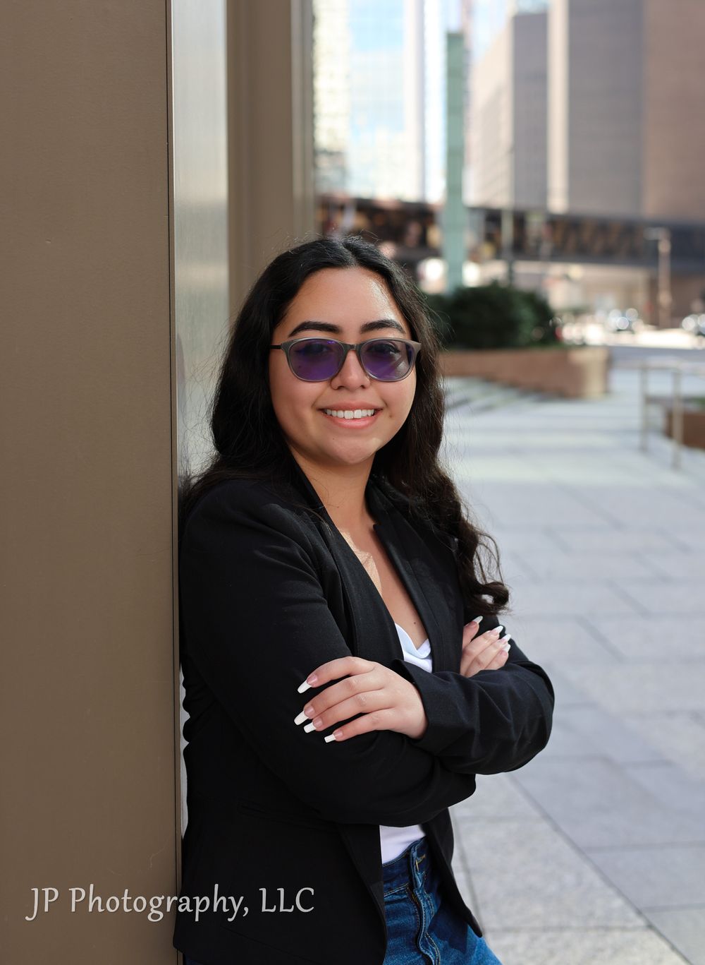 Professional outdoor portrait session in an urban setting with city architecture.
