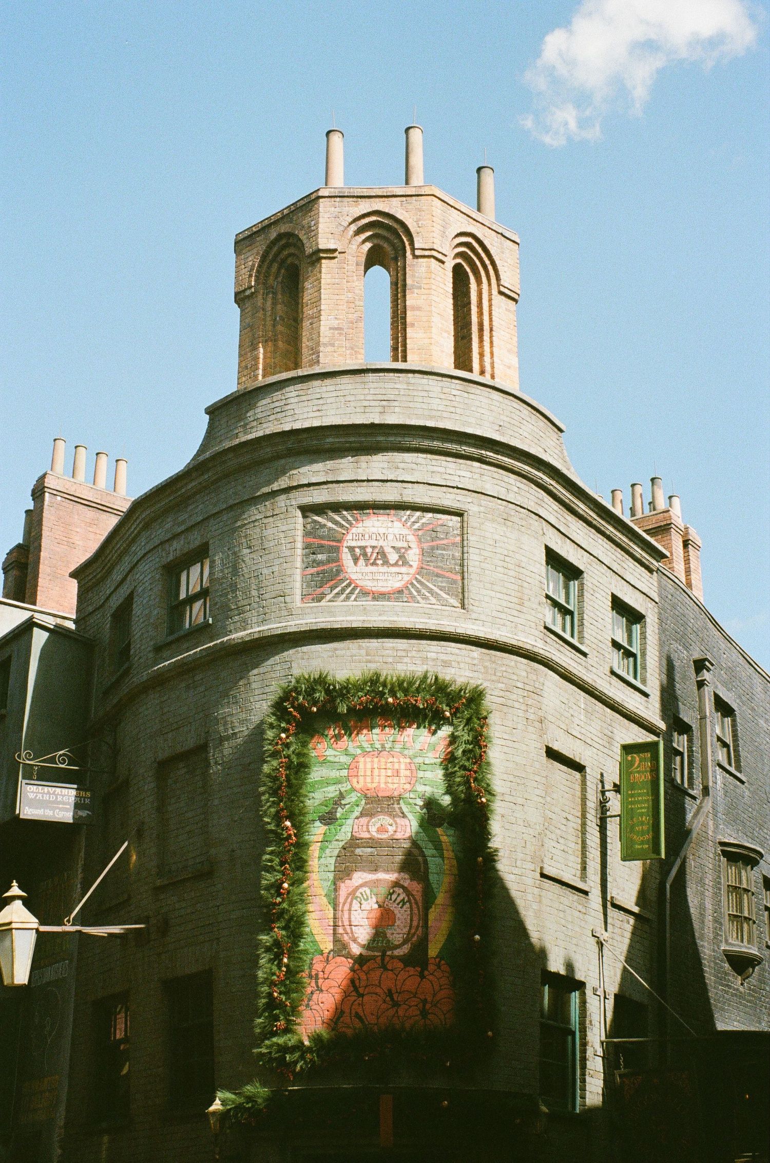 Historic curved building with domed tower and decorative greenery on brick facade.