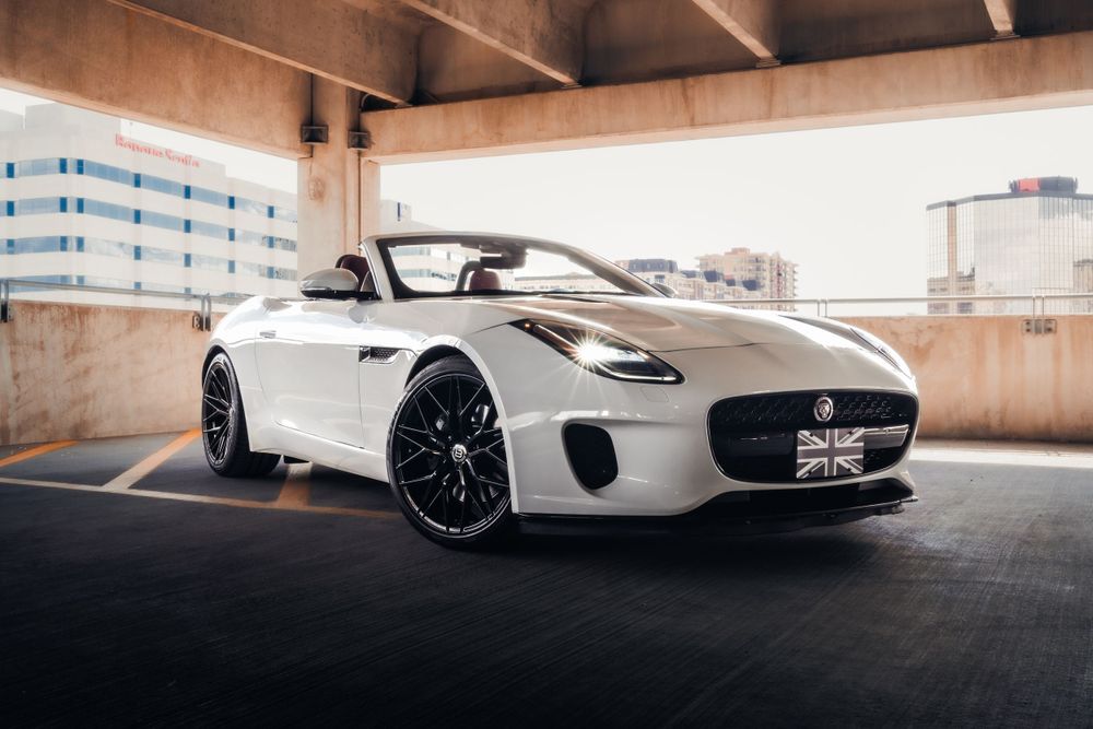 White Jaguar F-Type convertible with Union Jack detail parked in concrete structure. Mtlshutter photography