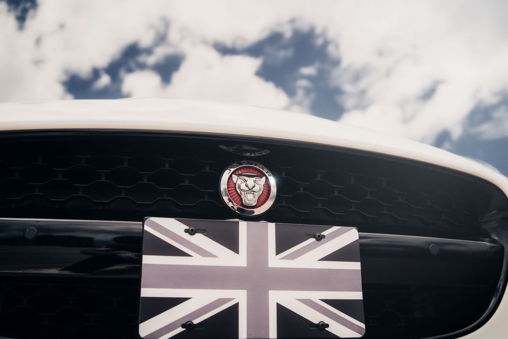 Close-up of Jaguar emblem with Union Jack flag detail on black grille. Mtlshutter photography