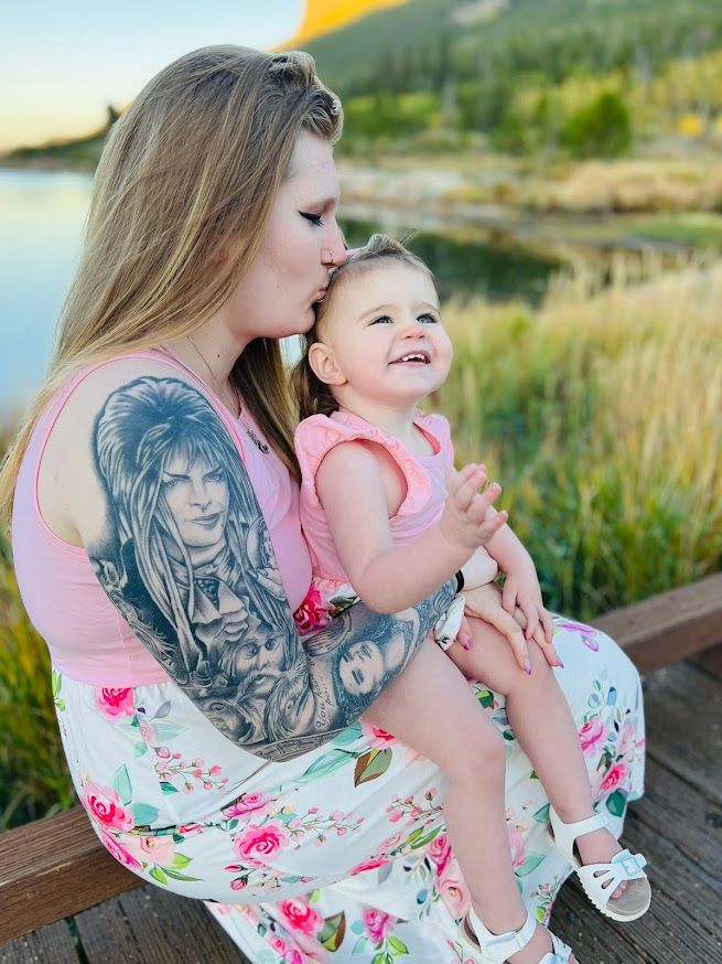 mom sitting with child kissing childs head