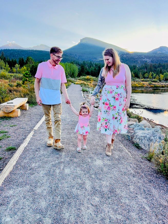 mom and dad walking holding childs hands