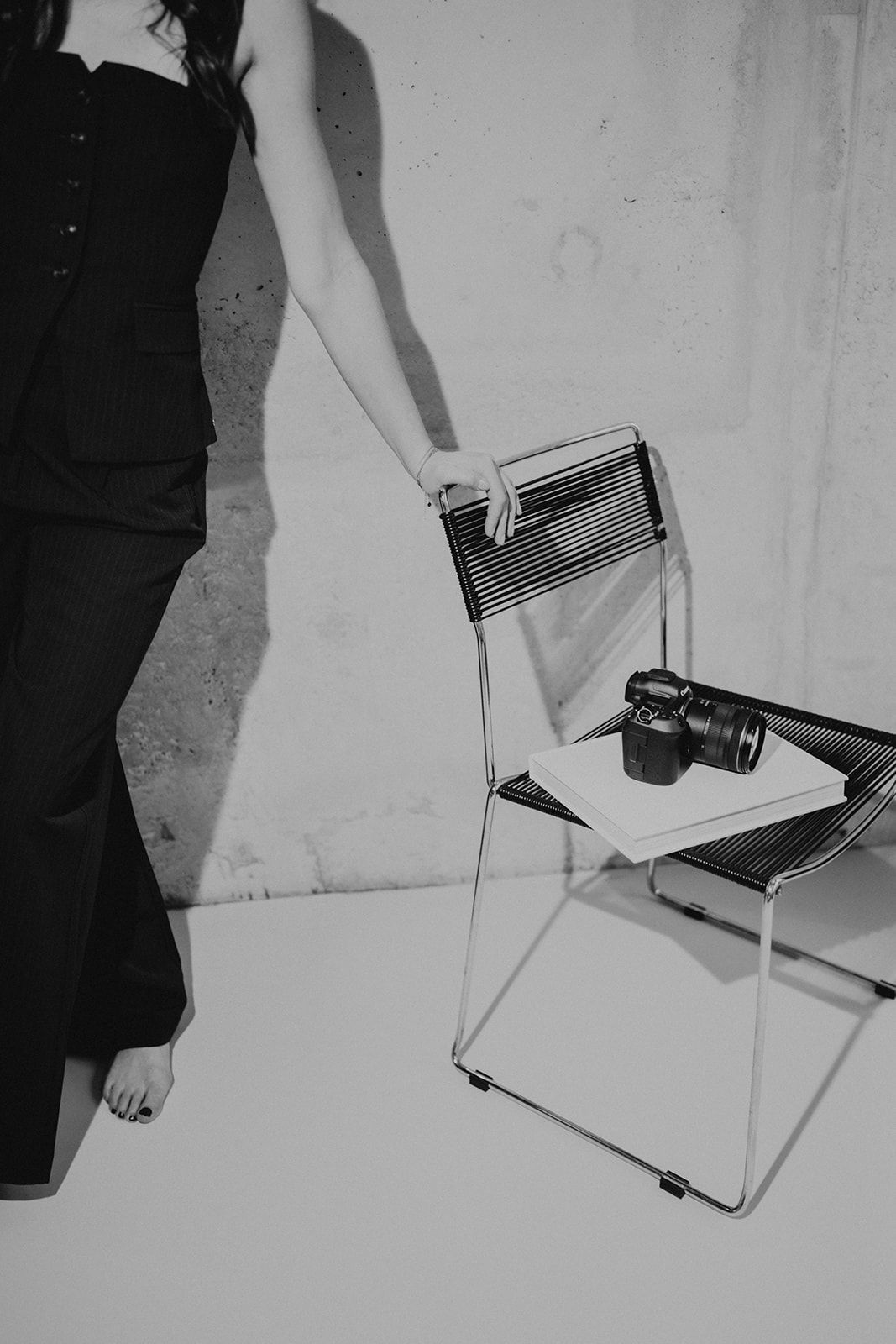 Black and white sequence showing hands manipulating paper or books against a white wall.