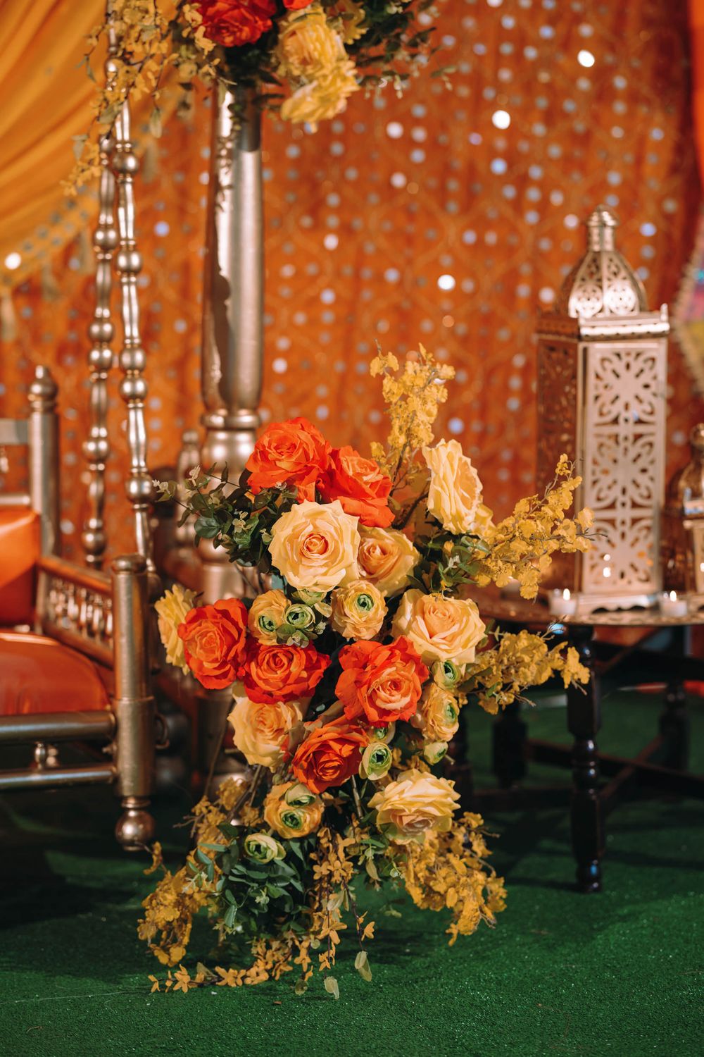 Elegant floral decorations with orange roses against a sparkly backdrop.