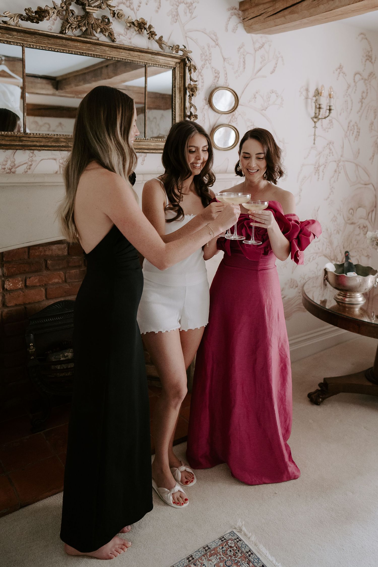 bride, sister and friend clinking glasses of champagne before getting into her dress at dewsall court in herefordshire