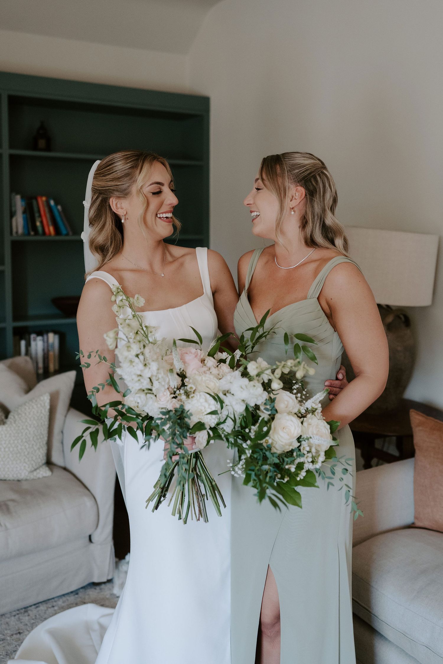 bride and sister laughing with each other at ivy lodge in cirencester