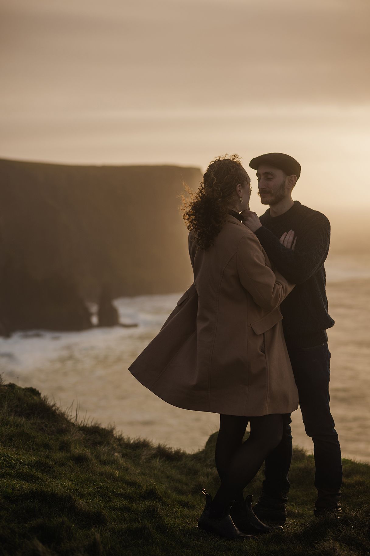 Romantic moment between couple watching sunset over the Atlantic Ocean at Doolin Cliff Walk