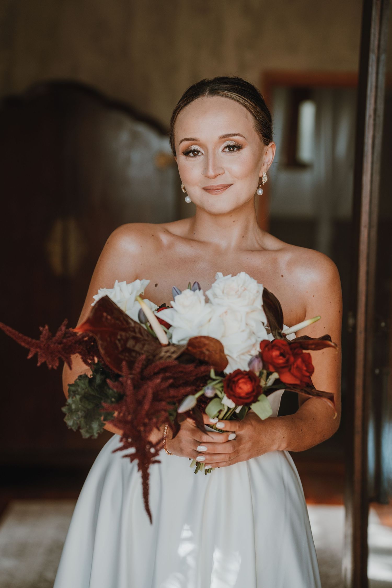A series of wedding photos showing white floral bouquets with burgundy accents held against a white bridal gown.