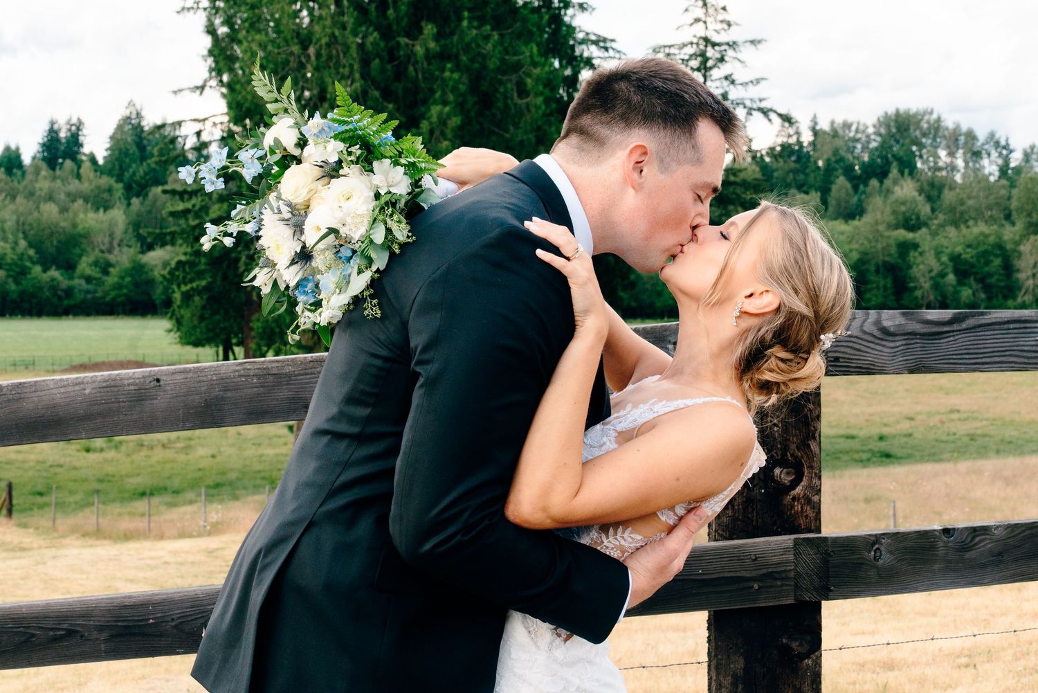 A romantic wedding couple embraces in an intimate moment with a long flowing veil.