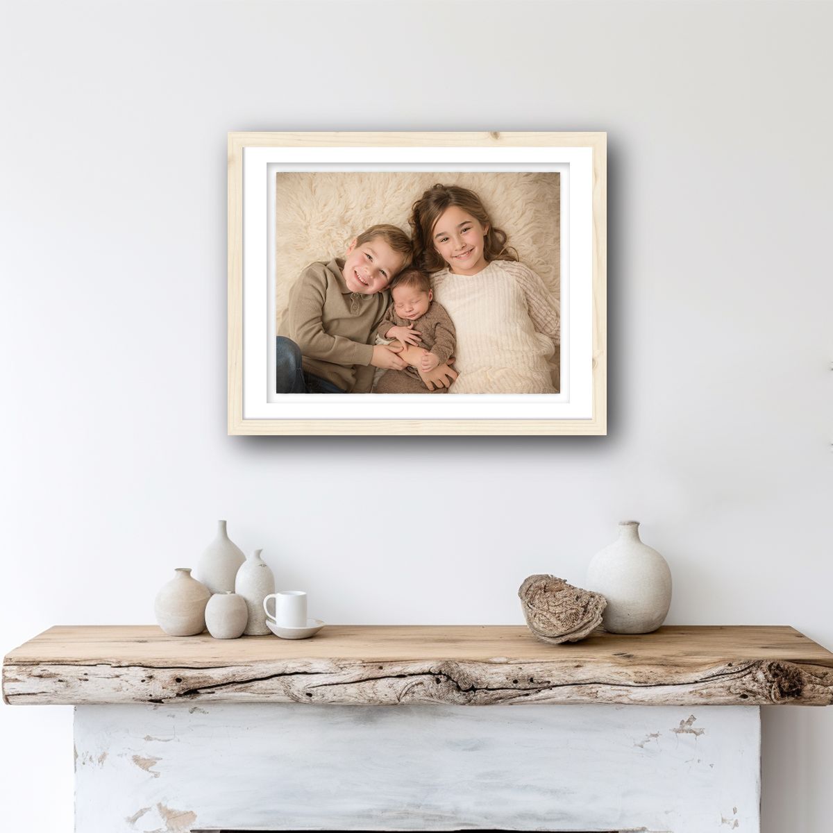 Minimalist white wall gallery display with framed artwork and a rustic wooden shelf creating an elegant composition.