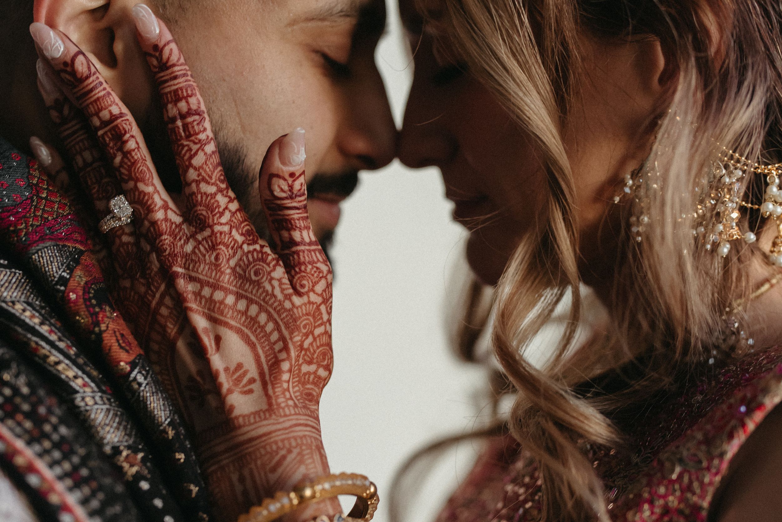 Close up view of traditional henna designs on hands during a wedding ceremony.