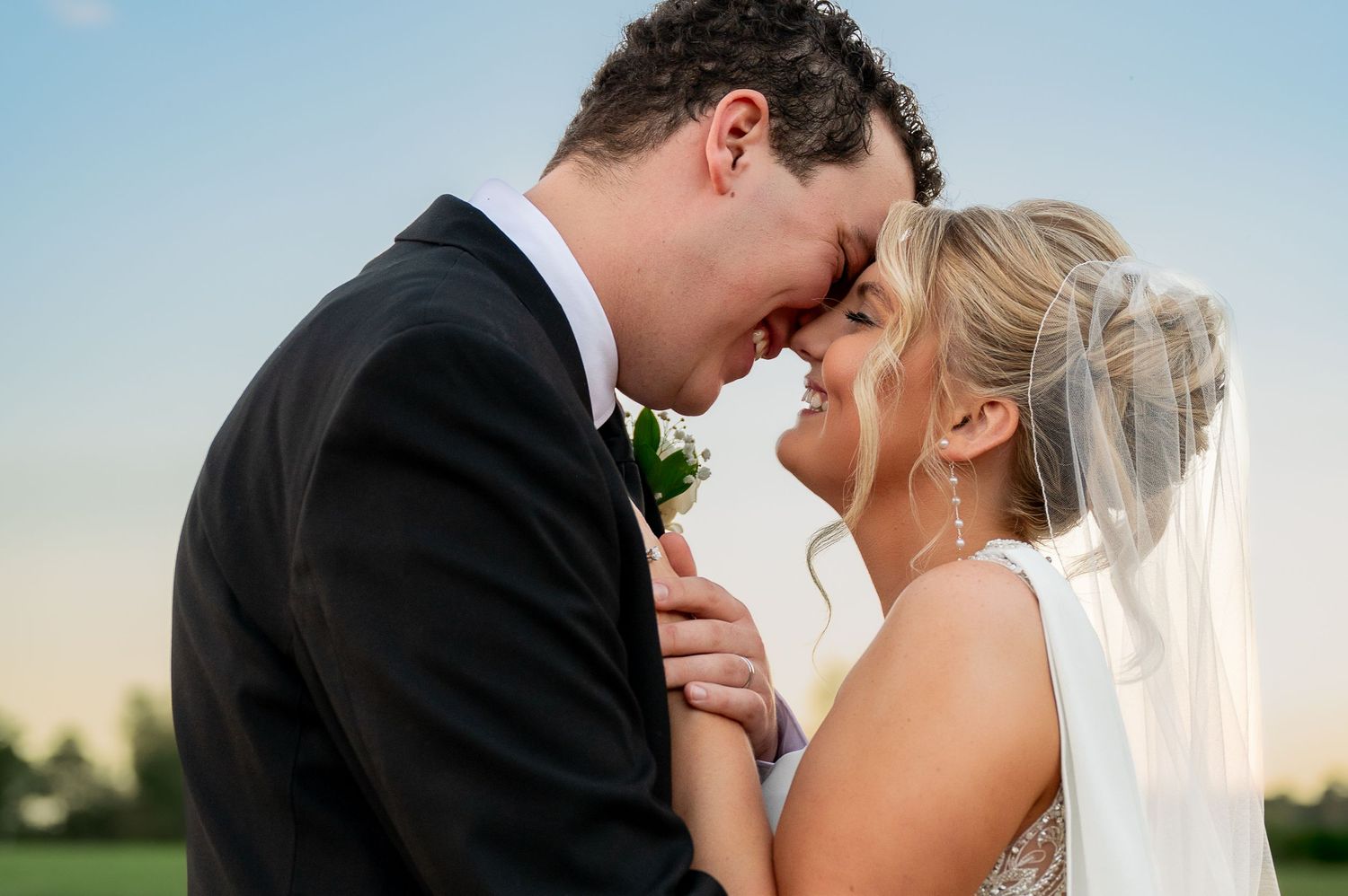 Intimate sunset moment between newlyweds during outdoor wedding portraits.