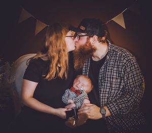 An intimate family portrait with triangle bunting decorations in moody lighting.