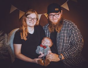 Professional family photography session with decorative bunting and natural elements.