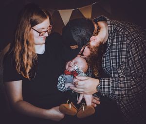 Intimate family portraits in dark setting with white banner decorations overhead.